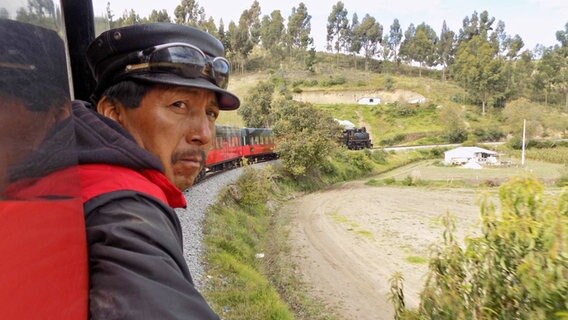 Ein Schaffner blickt auf die Strecke in den Anden aus dem Zug Tren Ecuador © NDR Foto: Solange Molina de Becker