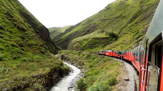 Ein roter Zug windet sich an einer Strecke der Anden hindurch in 4.000 Metern Höhe von Guayaquil bis Quito © NDR / Solange Molina de Becker 