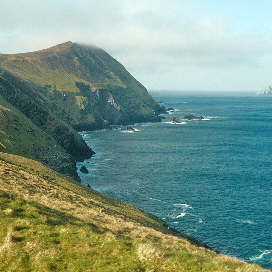 Ein Stück Küste von Irland, beschienen von der Sonne, voller schroffer Felsen, blauem Meer, und weißen Wolken © NDR Foto: Matthias Schuch