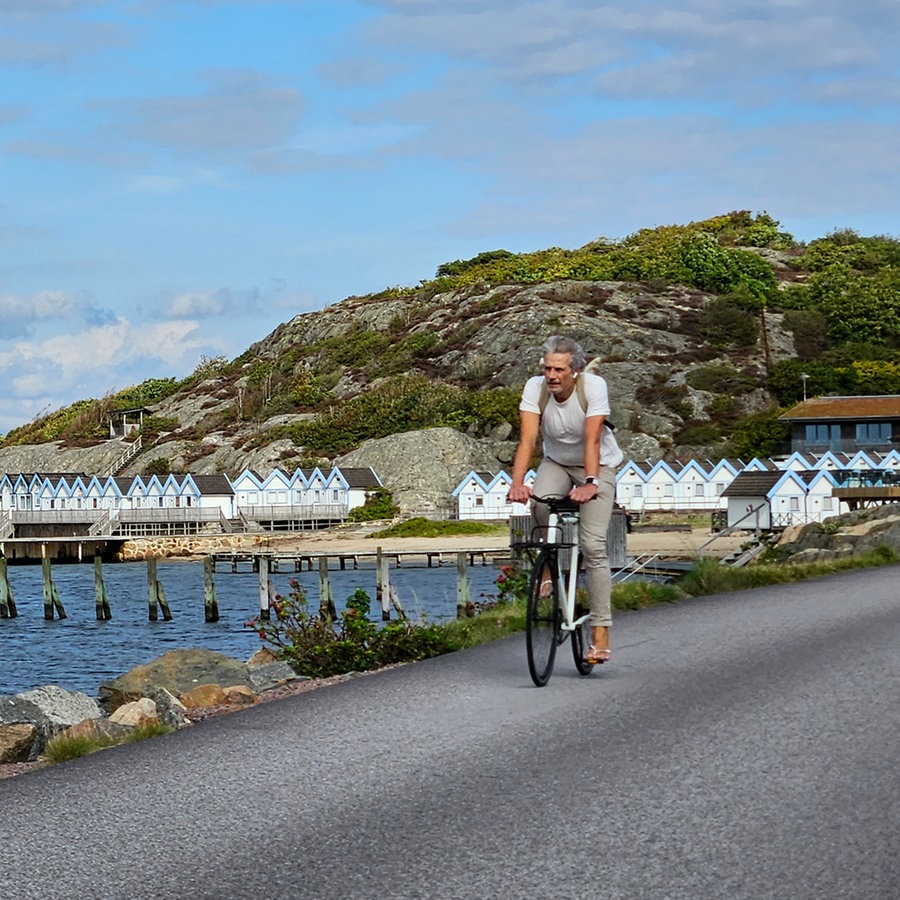 Ein Mann fährt Fahrrad am Rande des Meeres in Schweden © NDR Foto: Ulrike Keding