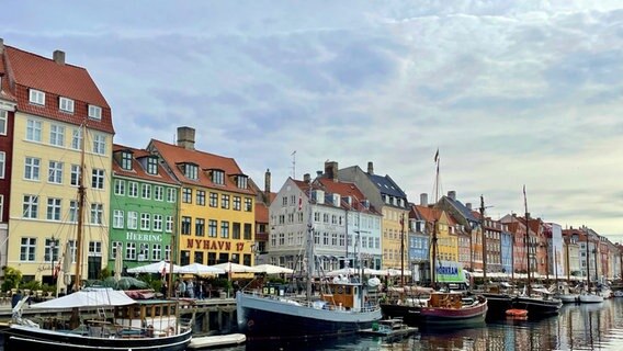 Bunte Fassaden der alten Häuser in Nyhavn in Kopenhagen, dazwischen in Kanälen die Segelschiffe und Yachten. © NDR Foto: Dennis Burk und Julia Küppers  