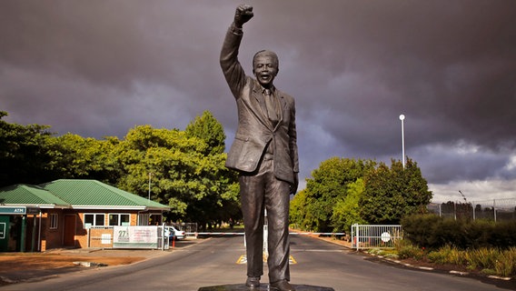 Eine Statue von Nelson Mandela in Südafrika vor seinem ehemaligen Gefängnis - mit empor gereckter Faust © picture alliance/AP Photo | Schalk Van Zuydam Foto: Schalk Van Zuydam