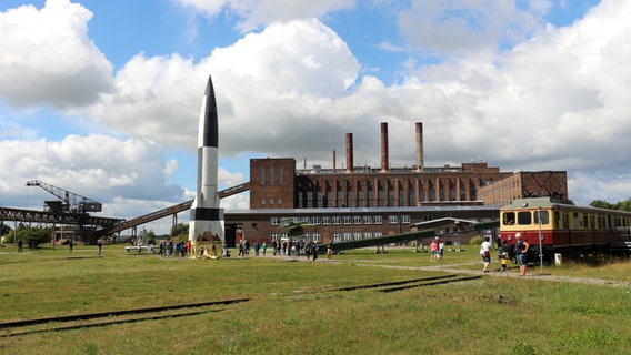Eine Rakete und ein alter Zug stehen vor einem Museum in Peenemünde © NDR Foto: Anja Steinbuch, Michael Marek