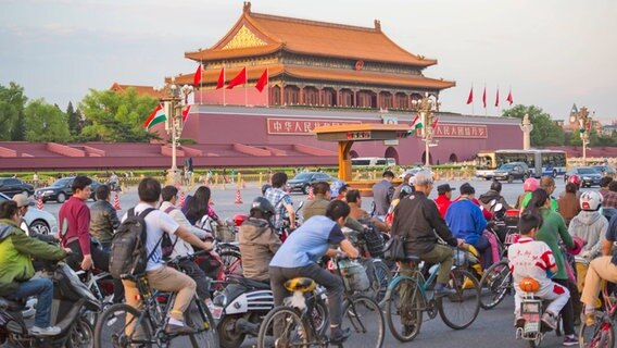 Der Platz des Himmlischen Friedens (Tian'anmen) im Jahr 2015 - Menschen auf Fahrrädern fahren am Platz vorbei © Picture alliance / Prisma / Raga Jose Fuste Foto: Raga Jose Fuste