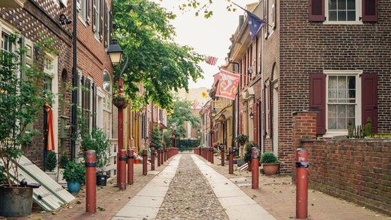 Eine Straße aus Steinhäusern mit Laternen und Steinboden - Elfreth's Alley in Philadelphia ist die älteste bewohnte Straße der USA © NDR Foto: Michael Marek
