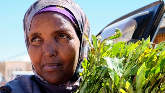 Eine Frau hält einen Khatstrauch in den Händen (in Somaliland) © NDR / Florian Guckelsberger Foto: Florian Guckelsberger