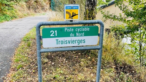 Ein Schild am Wegesrand weist auf den Vennbahn-Radweg hin - auf französisch steht dort "Piste cyclable du Nord - Troisvierges" © NDR Foto: Astrid Corall