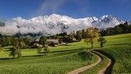 Der mit Schnee bedeckte Berg Wilder Kaiser, davor grüne Wiesen © NDR Foto: Alexander Tempel