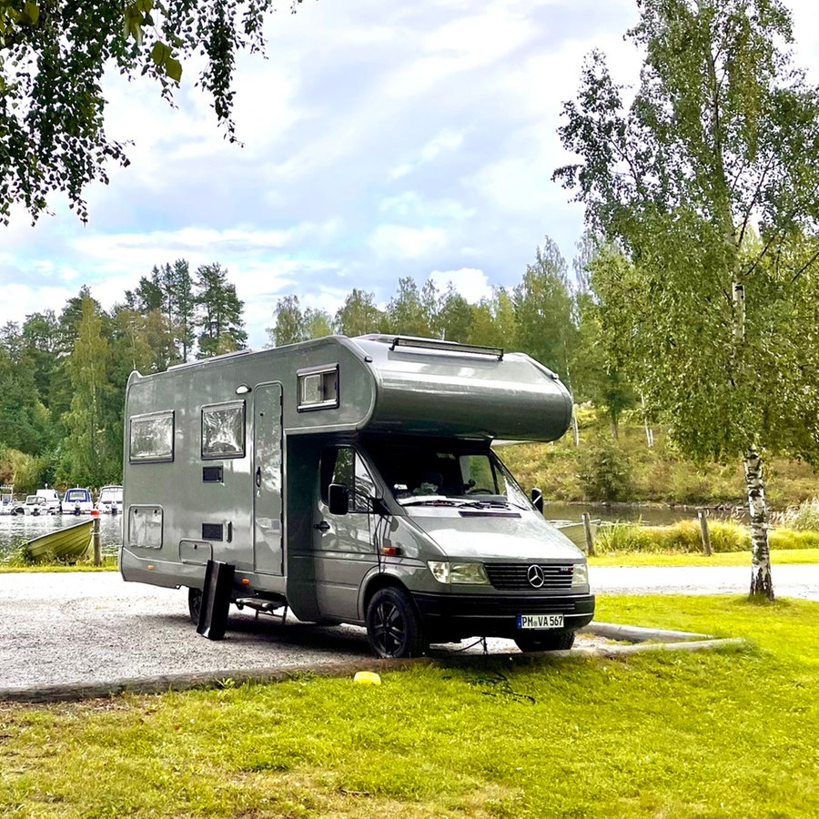 Ein Wohnmobil steht geparkt unter Birken auf einem Parkplatz in Finnland © NDR Foto: Vanja Budde