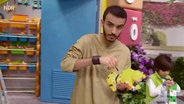 Szene aus einer Sesamstraßenfolge: Ein junger Mann repariert ein Spielzeug (Screenshot).  