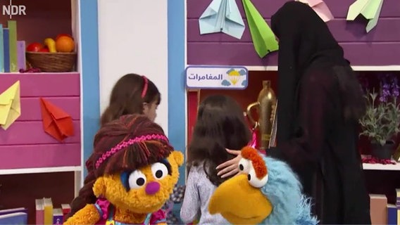 Szene aus einer Sesamstraßenfolge: Kinder und Monster in der Bibliothek (Screenshot).  