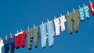 Socken hängen auf einer Wäscheleine. © dpa picture alliance Foto: Uwe Anspach