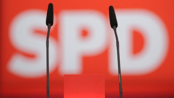 Vor einem verschwommenen SPD-Logo sind zwei Mikrofone zu sehen. © dpa picture alliance Foto: Julian Stratenschulte
