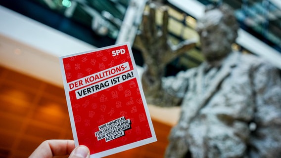 Ein Flyer der SPD auf dem "Der Koalitionsvertrag ist da!" steht. © dpa Bildfunk Foto: Kay Nietfeld/dpa