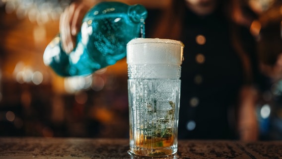 Sprudelwasser wird aus einer Flasche in ein Glar gegossen. © IMAGO Foto: Panthermedia