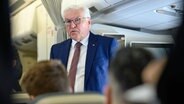 Bundespräsident Frank-Walter Steinmeier steht im Gang eines Flugzeugs. © Bernd von Jutrczenka/dpa 