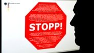 Ein Mann schaut auf einen Bildschirm mit dem Stoppschild © dpa - Bildfunk Foto: Jens Schierenbeck