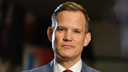 Hendrik Streeck gibt in Saarbrücken ein Interview, wo er für die Landespressekonferenz Saar die Goldene Ente an seinen Kollegen Jürgen Rißland überreicht. © picture alliance / BeckerBredel | BeckerBredel 