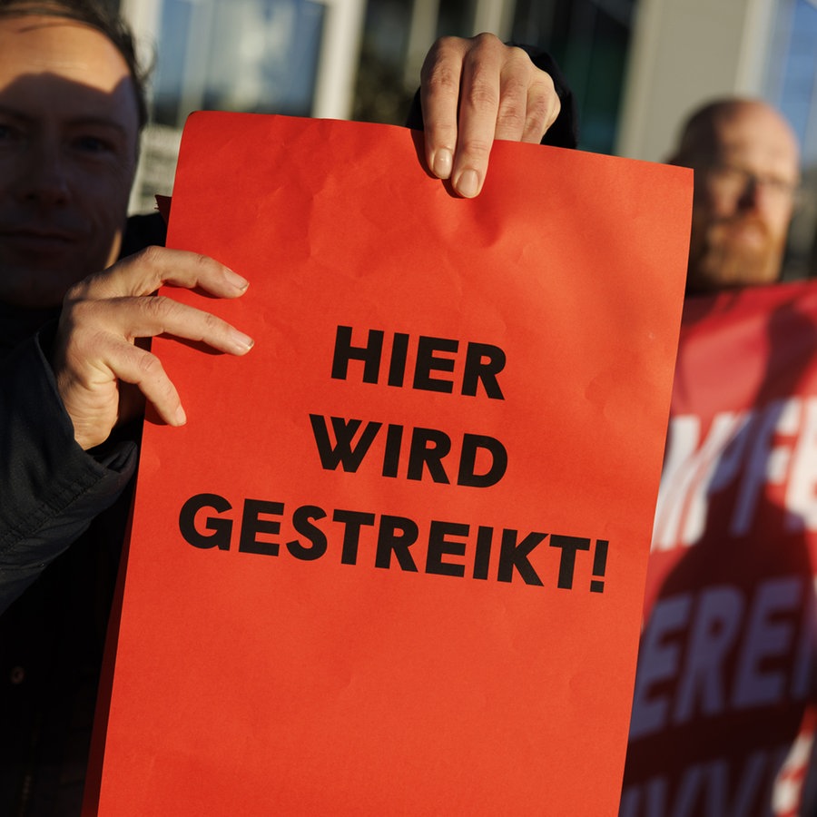 Streikende Angestellte. Ein Mann hält ein Schild hoch mit der Aufschrift: "Hier wird gestreikt!" © picture alliance / ERWIN SCHERIAU / APA / picturedesk.com Foto: ERWIN SCHERIAU