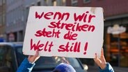 Eine Demonstrantin hält ein Schild hoch mit der Aufschrift: " Schild: Wenn wir Streiken steht die Welt still" © picture alliance / CHROMORANGE Foto: Michael Bihlmayer