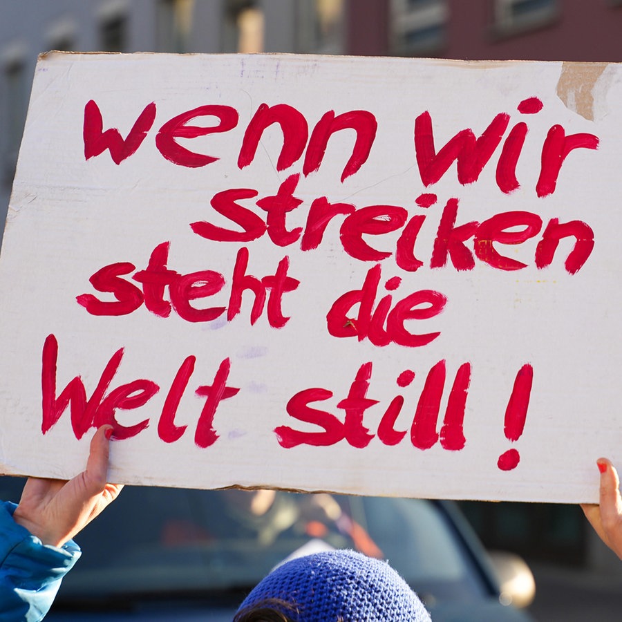 Eine Demonstrantin hält ein Schild hoch mit der Aufschrift: " Schild: Wenn wir Streiken steht die Welt still" © picture alliance / CHROMORANGE Foto: Michael Bihlmayer