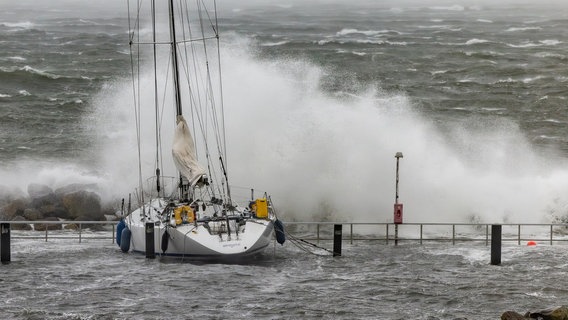 Schleswig-Holstein, Kiel: Meterhohe Wellen brechen sich an den Hafenanlagen in Schilksee. © dpa Bildfunk Foto: Axel Heimken/dpa