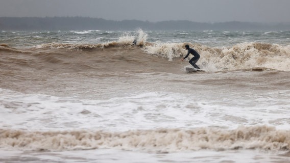 Schleswig-Holstein, Eckernförde: Ein Surfer ist in den Wellen der Ostsee unterwegs. © dpa Bildfunk Foto: Frank Molter/dpa