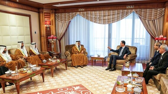 Scheich Mansour bin Zayed Al Nahyan (M,l),stellvertretender Präsident und stellvertretender Premierminister der Vereinigten Arabischen Emirate, im Gespräch mit Baschar al-Assad (M,r), Präsident von Syrien, am Rande des 32. Gipfel-Treffens der Arabischen Liga. © picture alliance/ SANA (offizielle syrisch-arabische Nachrichtenagentur) 