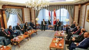 Kais Saied, Präsident von Tunesien, im Gespräch mit Bashar al-Assad (Mitte,l), Präsident von Syrien, am Rande des 32. Gipfel-Treffens der Arabischen Liga. © picture alliance/ SANA (offizielle syrisch-arabische Nachrichtenagentur) 