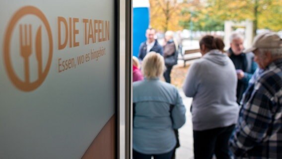 Bedürftige Menschen warten vor einer Lebensmittel-Tafel. © dpa 