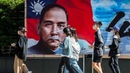Taiwan: Passanten gehen an einem Plakat von Sun Yat-sen, dem ehemaligen Präsidenten von China, in der Innenstadt von Taipeh vorbei. © ZUMA Press Wire/dpa Foto: Wiktor Dabkowski
