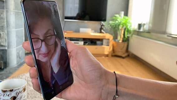 Während eines Video-Telefonats ist auf einem Smartphone Tanja Koktash zu sehen. © NDR Foto: Sabine Hausherr