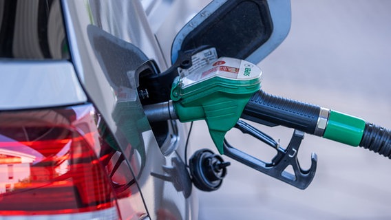 Die Zapfpistole für Super-Kraftstoff steckt in einer Tankstelle im Tankstutzen eines Autos. © dpa-Zentralbild/dpa Foto: Jens Büttner
