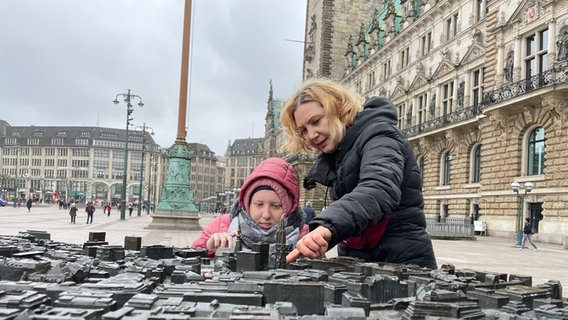 Tetyana Novakova lässt ihre Tochter Anastasija am Stadtrelief vor dem Rathaus die Hamburger City ertasten. © NDR/Lea Eichhorn Foto: Lea Eichhorn