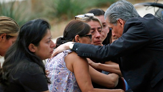 Gustavo Garcia Seller (r), Erzbischof von San Antonio, tröstet Familien nach dem Amoklauf an einer Grundschule in der Kleinstadt Uvalde im US-Bundesstaat Texas. © Dario Lopez-Mills/AP/dpa 