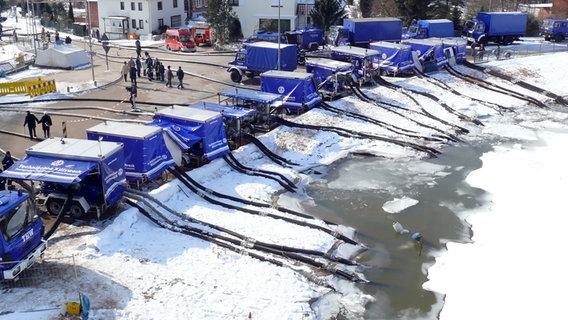 Mehrere THW-Autos haben ihre Pumpschläuche in einen Teich ausgeworfen. © THW 