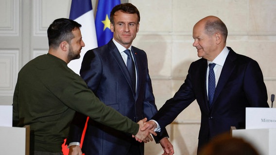 Emmanuel Macron (M), Präsident von Frankreich, Bundeskanzler Olaf Scholz (r.) und Wolodymyr Selenskyj, Präsident der Ukraine, begrüßen sich © dpa-Bildfunk Foto: Sarah Meyssonnier/Pool Reuters/AP/dpa