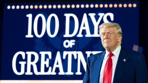 US-Präsident Donald Trump kommt an, um im Macomb County Community College Sports Expo Center über seine ersten 100 Tage im Amt zu sprechen. © picture alliance/dpa/AP Foto: Alex Brandon