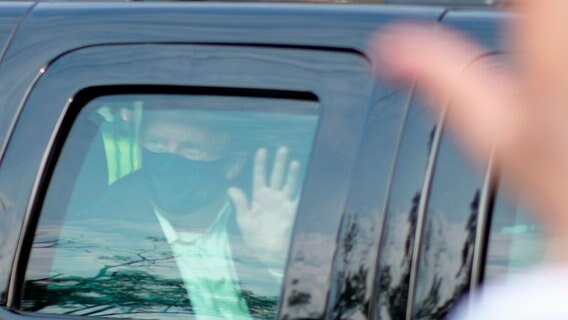 Donald Trump, Präsident der USA, sitzt in einem Auto und winkt durchs Fenster. © dpa bildfunk/AP Foto: Tony Peltier
