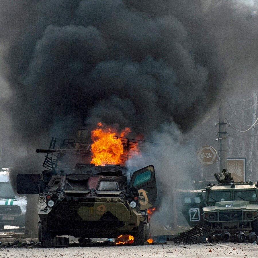 Ein gepanzerter Mannschaftswagen brennt nach Kämpfen im ukrainischen Charkiw auf einer Straße © AP/dpa Foto: Marienko Andrew