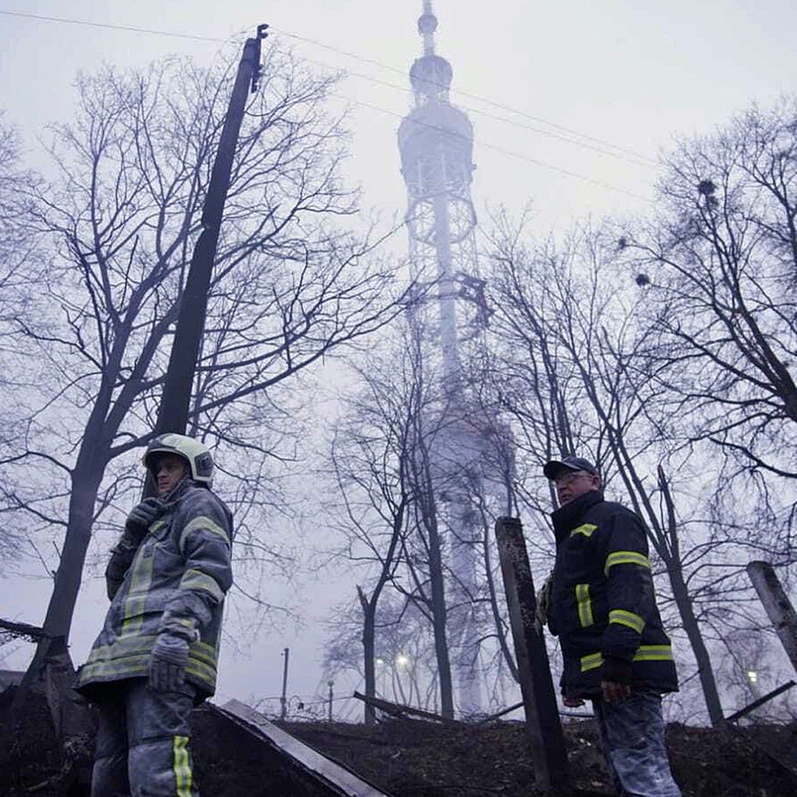 Rettungskräfte stehen nach einer Raketenexplosion in der Nähe vor dem Fernsehturm in Kiew. © dpa picture alliance/AA|State Emergency Service of Ukraine/Handout 