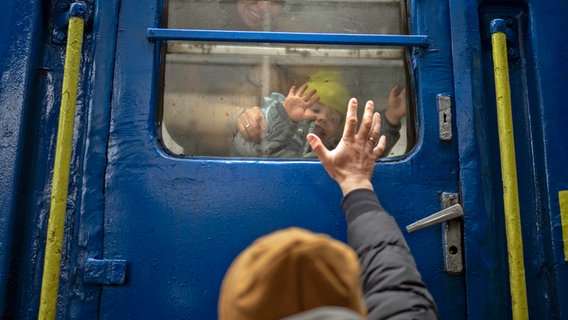 Stanislaw verabschiedet sich von seinem Sohn David und seiner Frau Anna in einem Zug nach Lwiw am Bahnhof von Kiew, Ukraine. Stanislaw bleibt um zu kämpfen, während seine Familie das Land verlässt und in einem Nachbarland Zuflucht sucht. © dpa-Bildfunk 