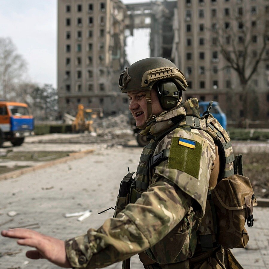 Ein ukrainischer Soldat steht bei einem zerstörten Gebäude in der Stadt Mykolajiw. © dpa Bildfunk/AP Foto: Petros Giannakouris