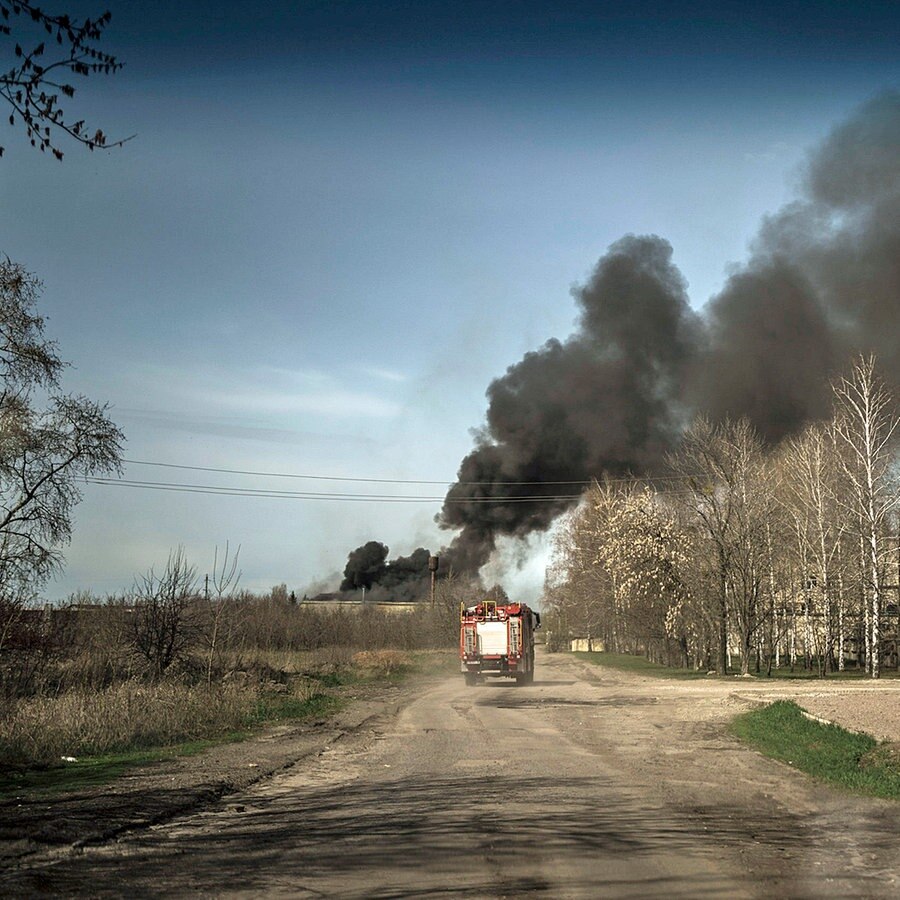 Feuerwehrleute fahren zu einem Brand in einer Fabrik nach einem russischen Angriff in den Außenbezirken von Charkiw. © dpa Bildfunk/AP Foto: Felipe Dana