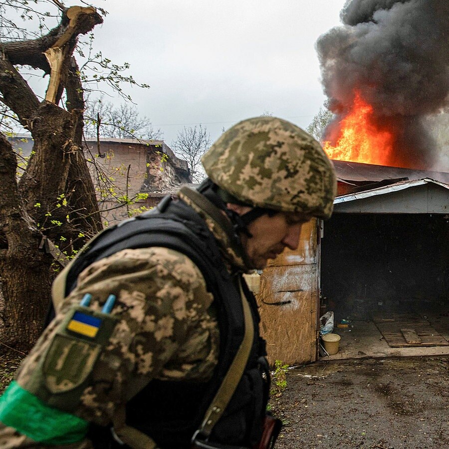 Ein ukrainischer Soldat geht an einer brennenden Garage in der Stadt Charkiw vorbei. © dpa Bildfunk/SOPA Images via ZUMA Press Wire Foto: Alex Chan Tsz Yuk