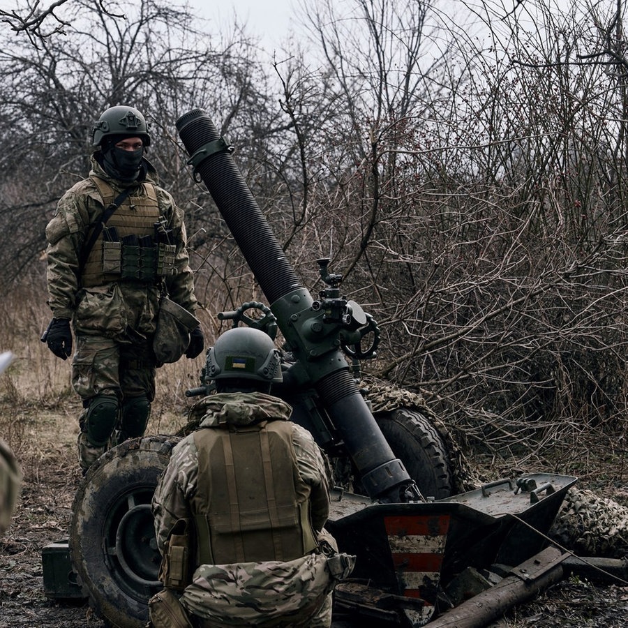 Freiwillige Soldaten bereiten sich auf das Feuer auf russische Stellungen vor. © picture alliance/dpa/Libkos/AP 