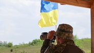 Soldat der Nationalgarde der Ukraine blickt durch ein Fernglas © Ukrinform/dpa 