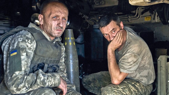 Ukrainische Soldaten sitzen in einer Panzerhaubitze an der Frontlinie. © Libkos/AP/dpa 