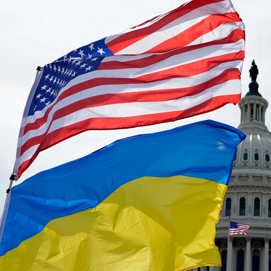 Die US-amerikanische und die ukrainische Flagge wehen vor dem Kapitol in Washington im Wind. © Mariam Zuhaib/AP/dpa 