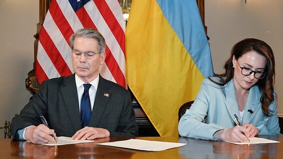 US-Finanzminister Scott Bessent und die ukrainische Vizeregierungschefin Julia Swyrydenko unterzeichnen das Vertragswerk zur Einrichtung eines Wiederaufbaufonds. Vorgesehen ist ein Investitionsfonds zur gemeinsamen Ausbeutung ukrainischer Bodenschätze, der Mittel zum Wiederaufbau des kriegszerstörten Landes erwirtschaften soll. © -/US Treasury Departement/dpa 